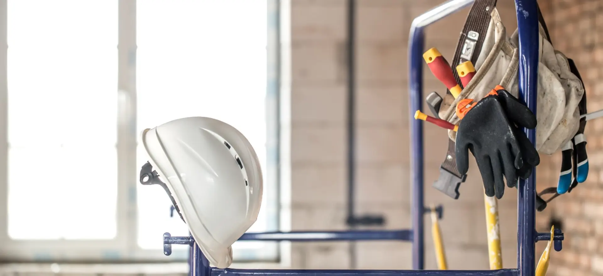 Ferramentas de construção civil e capacete de segurança em obra